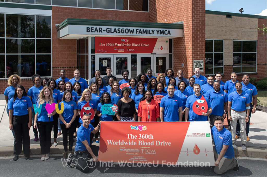 group photo of weloveu volunteers, Dr. Nina Anderson, and City Treasurer Velda Jones-Potter outside the Bear-Glasgow YMCA in Newark, DE