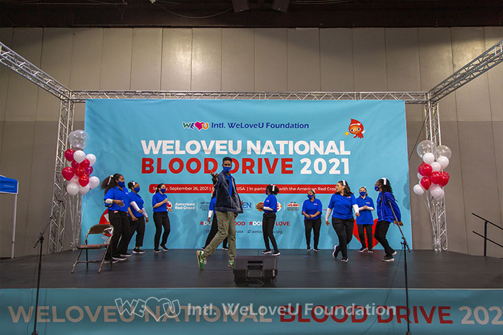 Musical artist Mr. Hotspot performs on stage with the WeLoveU cheer squad