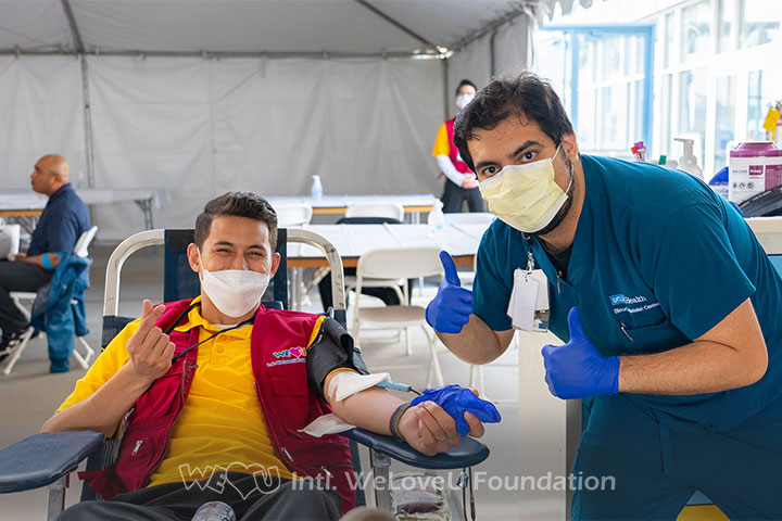 A blood donor and phlebotomist at a WeLoveU blood drive