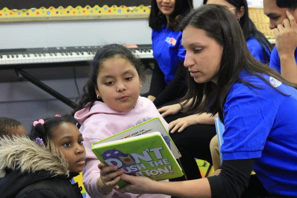 WeLoveU volunteer reads a book to children