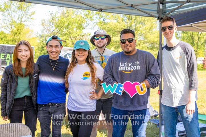Amazon employees holding the WeLoveU logo