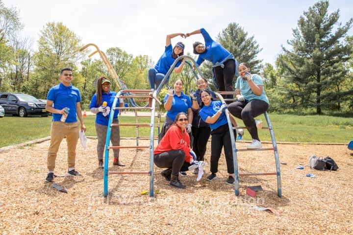 Volunteers sitting on playground bars