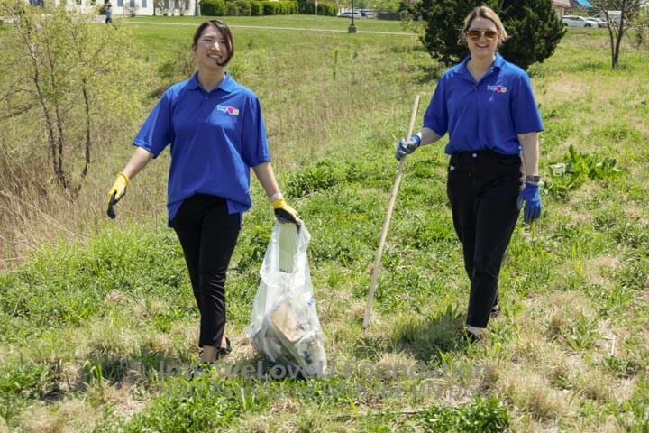Two WeLoveU volunteers picking up trash