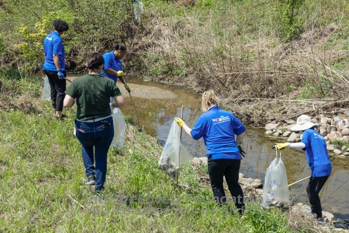 WeLoveU and Antunes looking for trash near water
