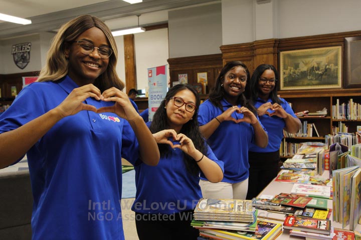 WeLoveU volunteers making hearts with their hands